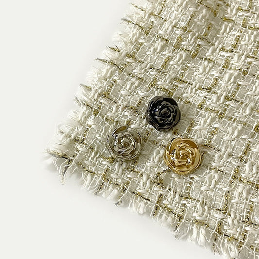Boutons métal roses avec tiges (noir, argent, doré clair) sur tissu texturé, vue de dessus