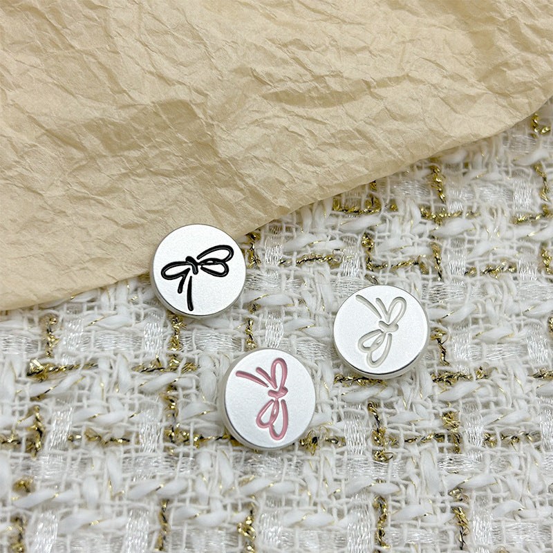 Round metal flat buttons with shanks: black & white bow outlines, plus pink bow