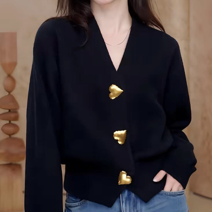 Antique gold heart-shaped buttons on a dark V-neck cardigan front