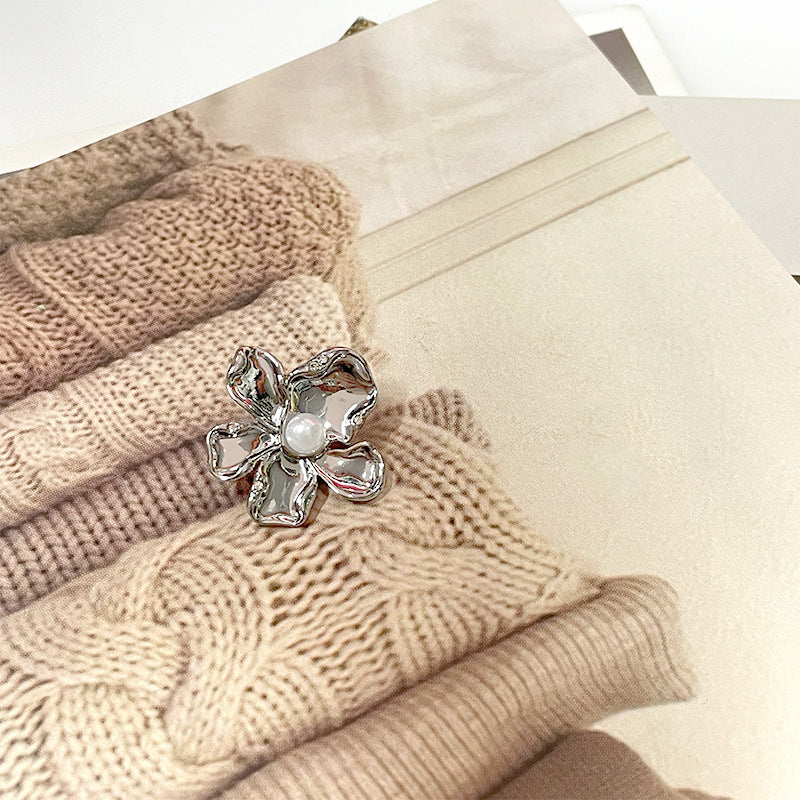 Silver flower-shaped metal sewing button with central pearl and diamond-like inlays