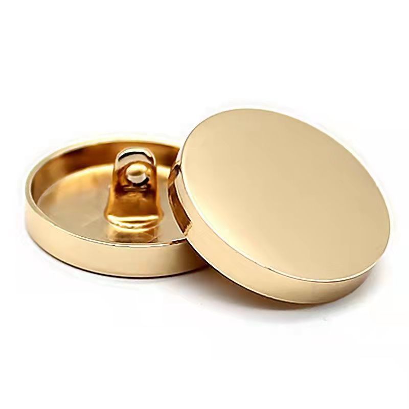 Bright gold round sewing button with shank, mirror-finish face, flat back view