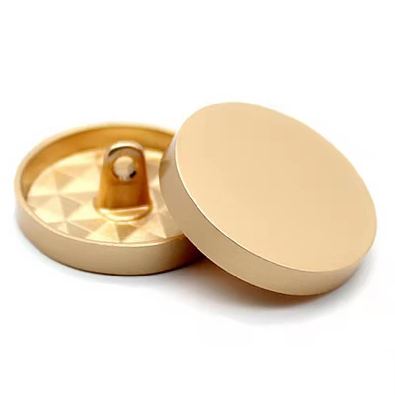 Gold round metal sewing button with shank, mirror-finish front, open back