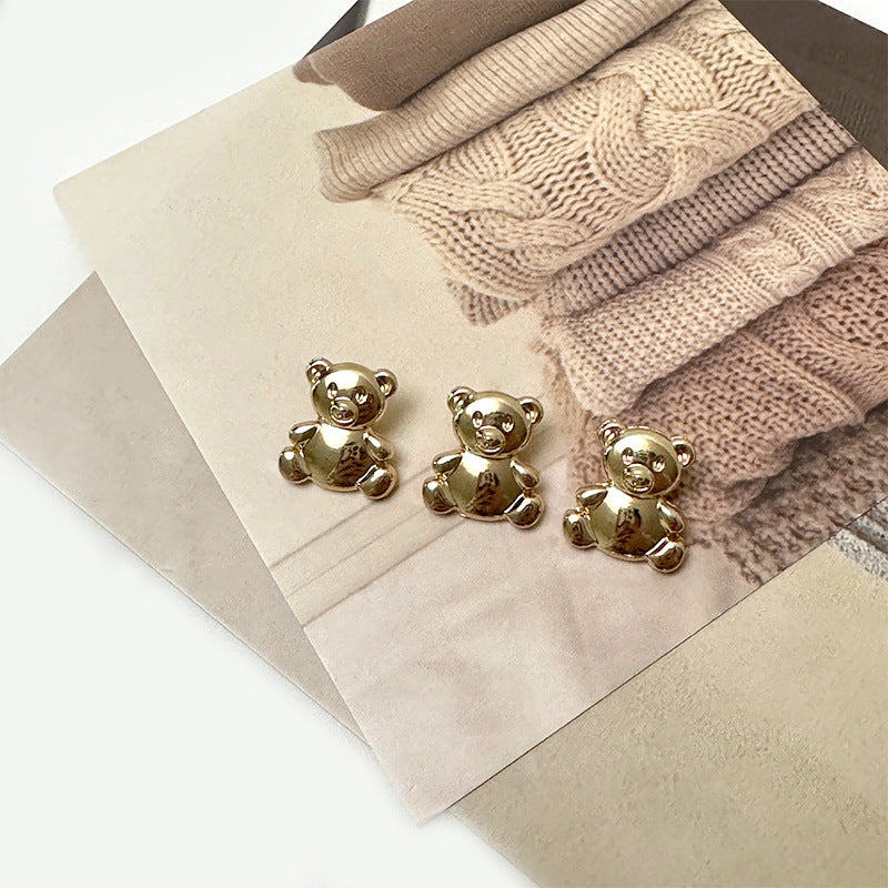 Set of light gold metal cartoon bear buttons on paper, 3-pack view