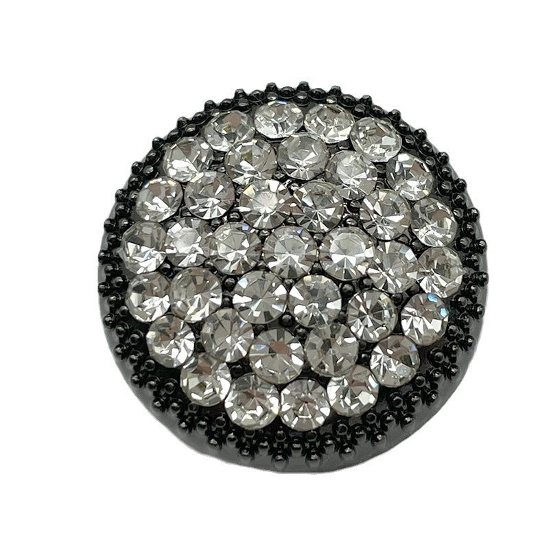 Round rhinestone button with clear crystals set on a black metal bezel