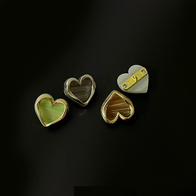 Heart-shaped metal buttons, light green front and gold back with visible shanks
