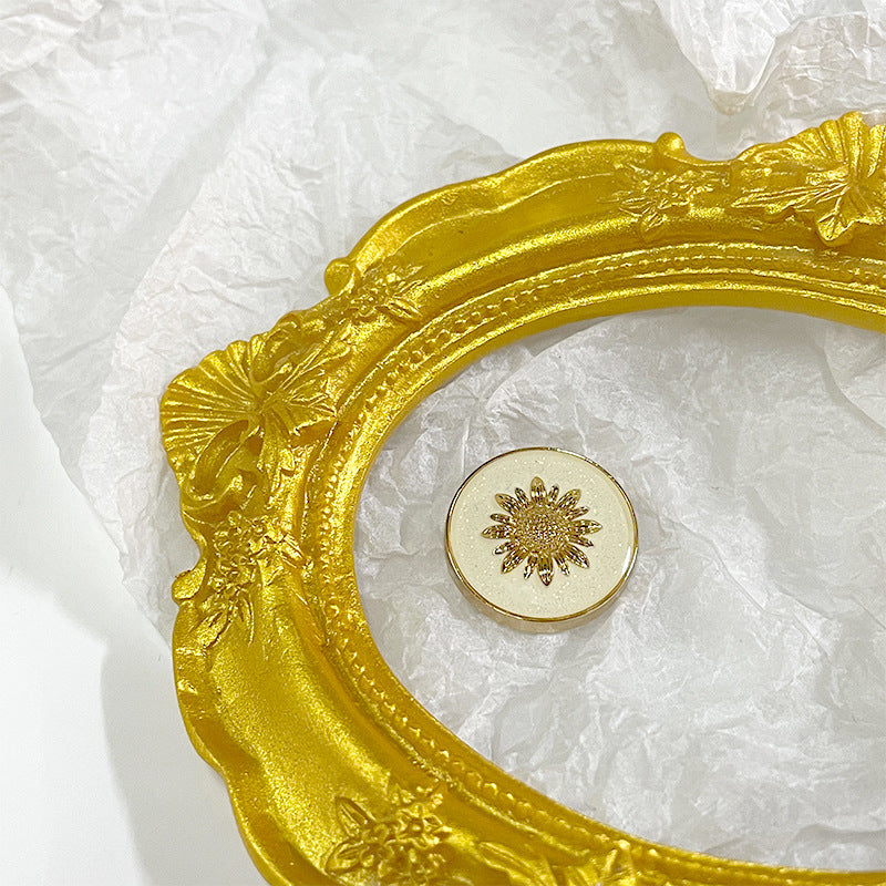 White sunflower metal shank button with gold painted flower motif on round face
