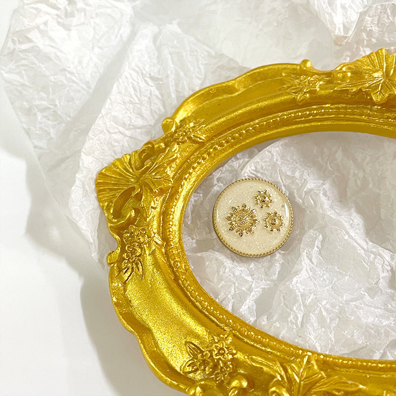 White sunflower metal shank button, gold painted snowflake-style flower details on face