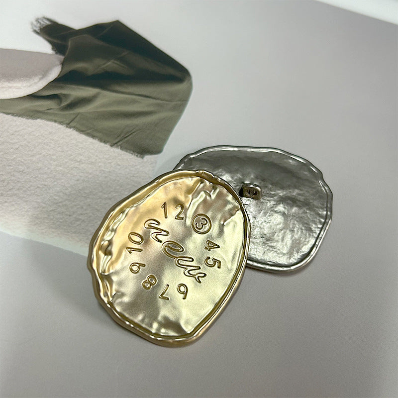 Gold and silver oval alloy buttons with embossed numbers around 12 and metal shanks