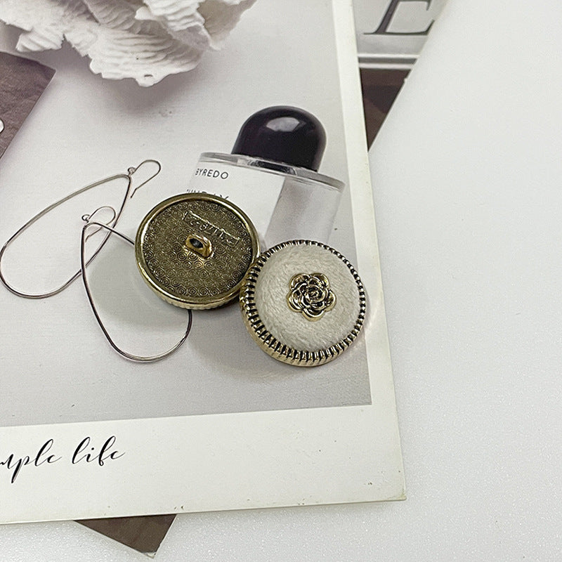 Flocked camellia metal button pair: gold-tone back and white fabric with gold rose center