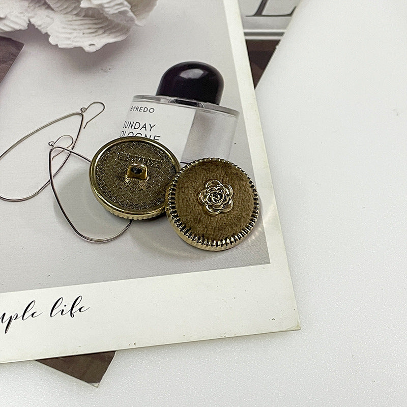 Flocked camellia metal button pair: gold-tone back and olive-gold fabric with rose center