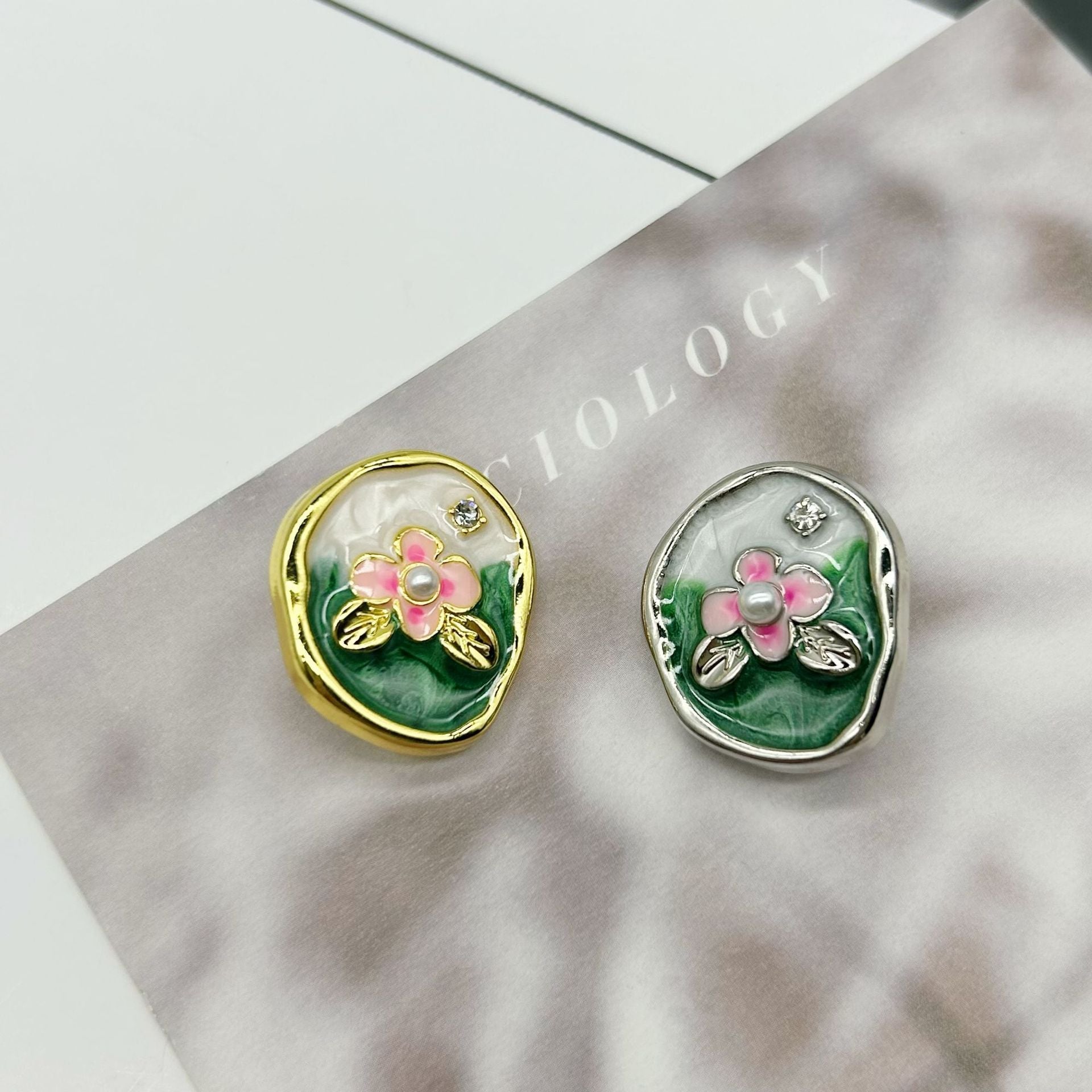 Oval flower buttons pair: gold & silver, pink petals, pearl center, rhinestone accents
