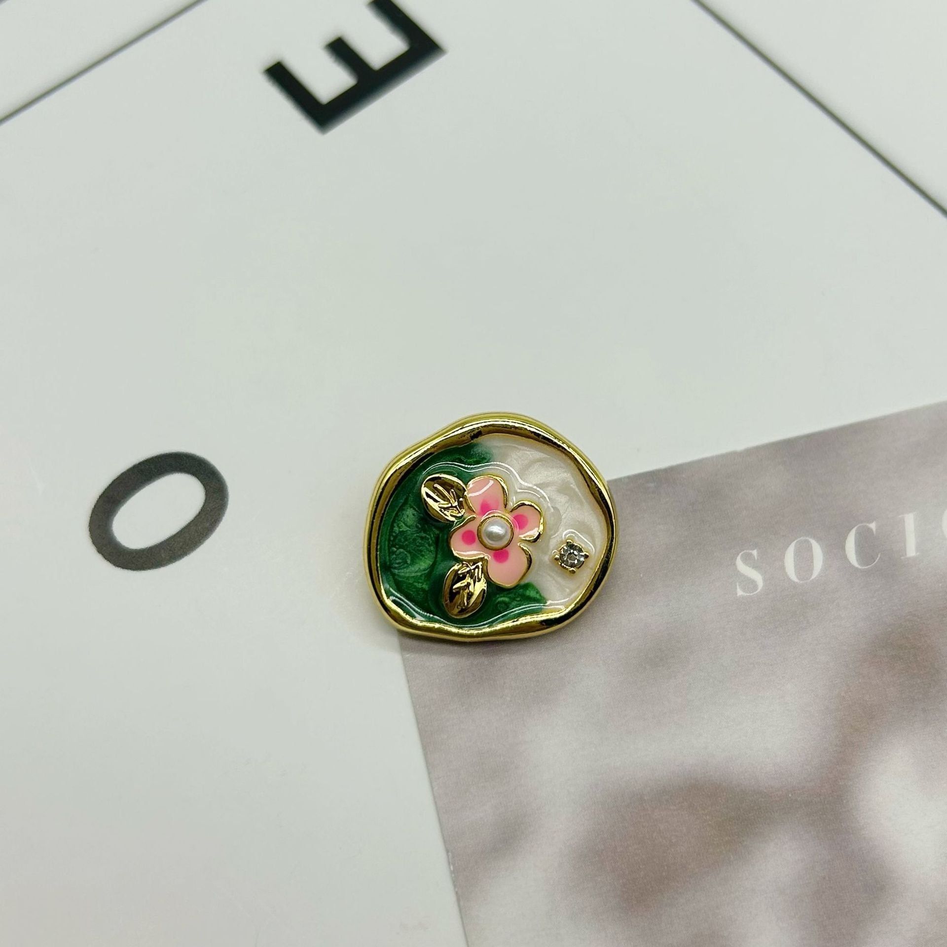 Gold oval flower button with green leaf enamel, pink petals and pearl center