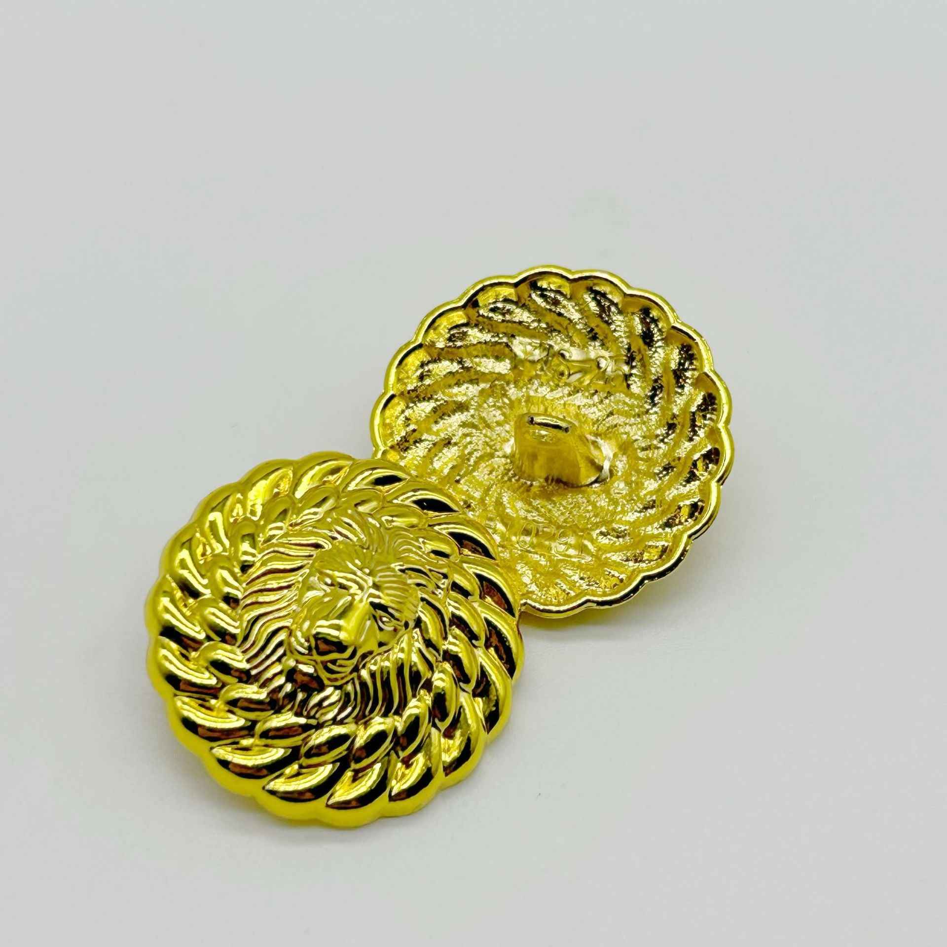 Pair of round lion head buttons in gold finish, detailed mane and facial features