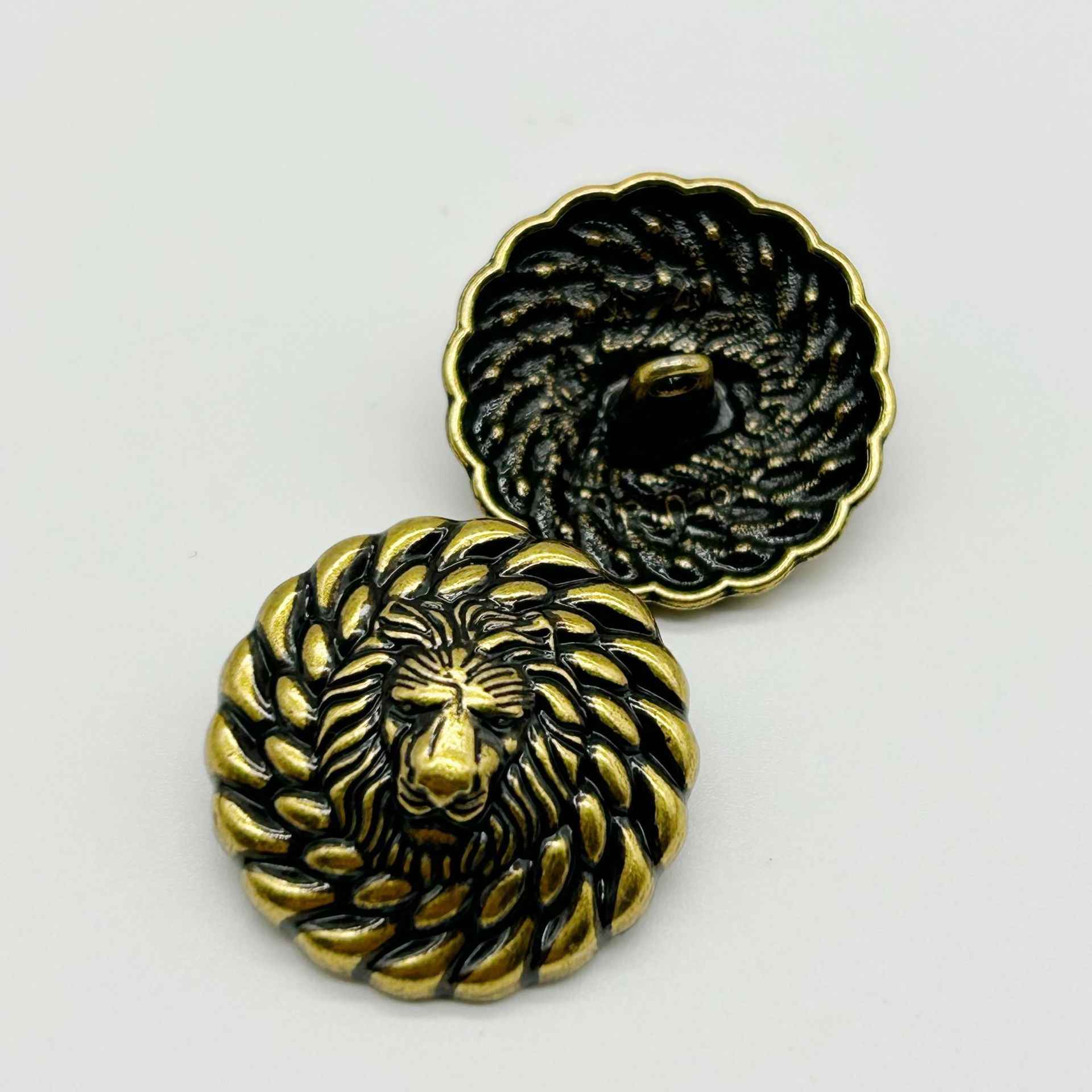 Round lion head button pair: one gold front and one dark gold reverse, embossed detail