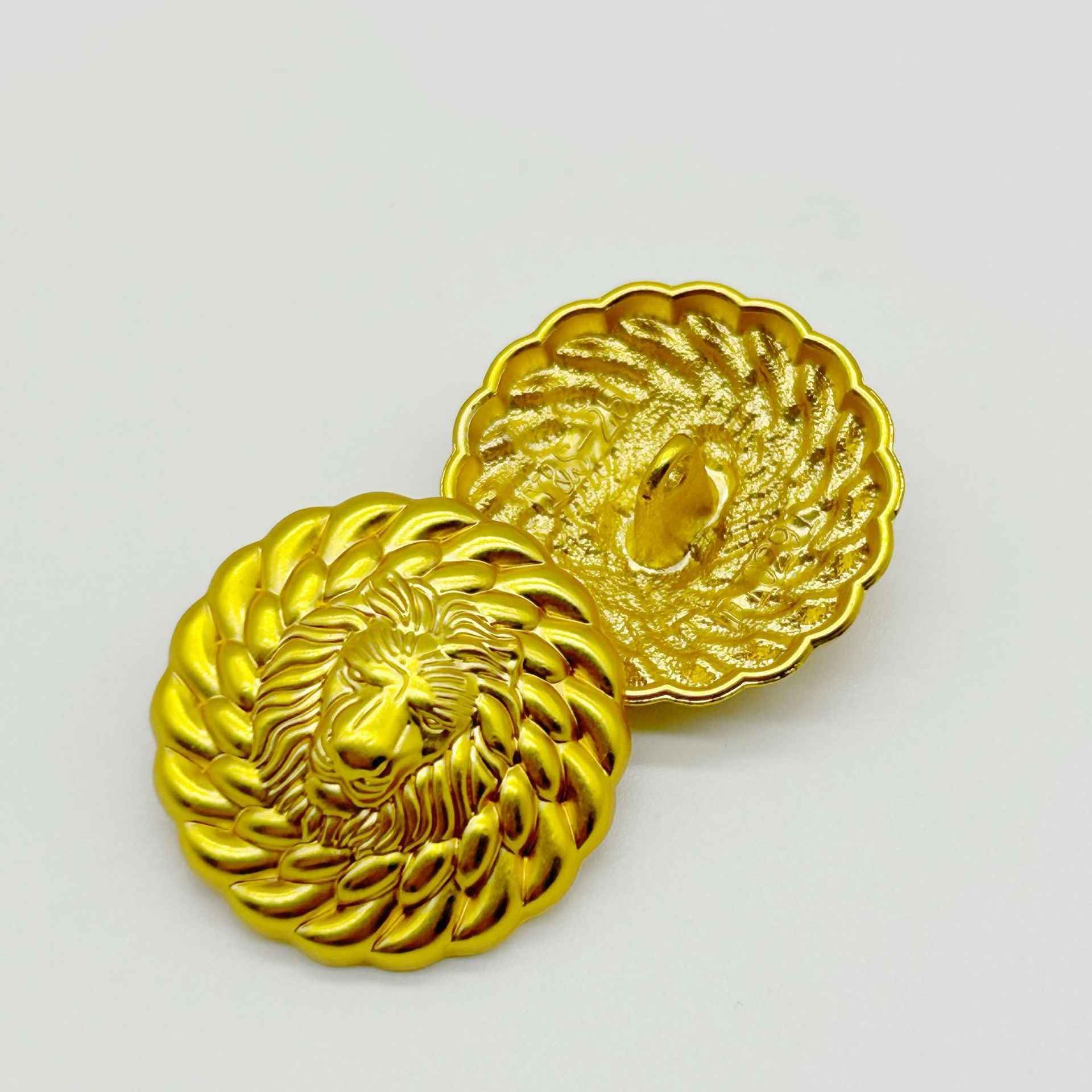 Two bright gold lion head buttons, round with embossed mane and lion face details