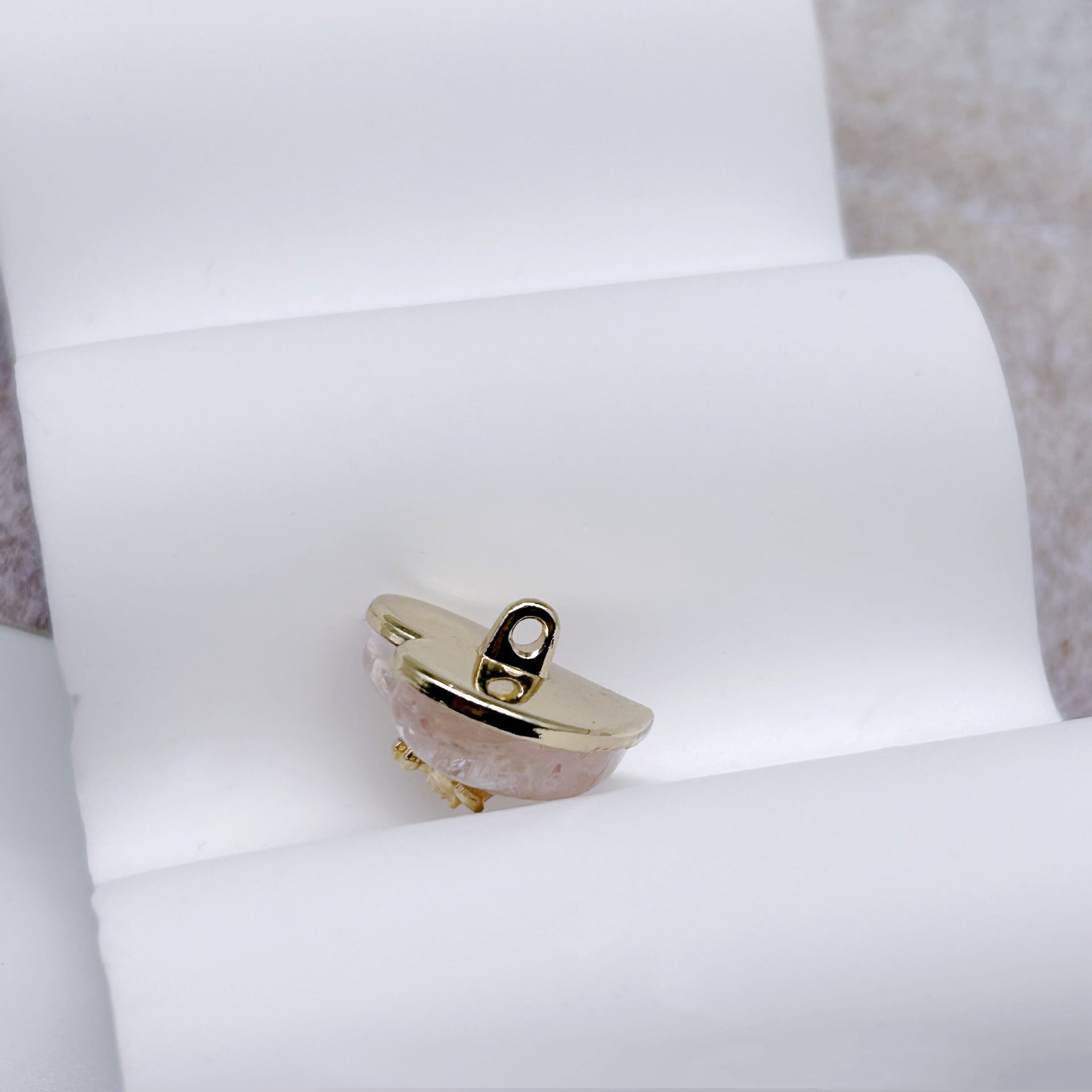 Heart-shaped button with metal rim and resin face, gold-tone shank backing visible