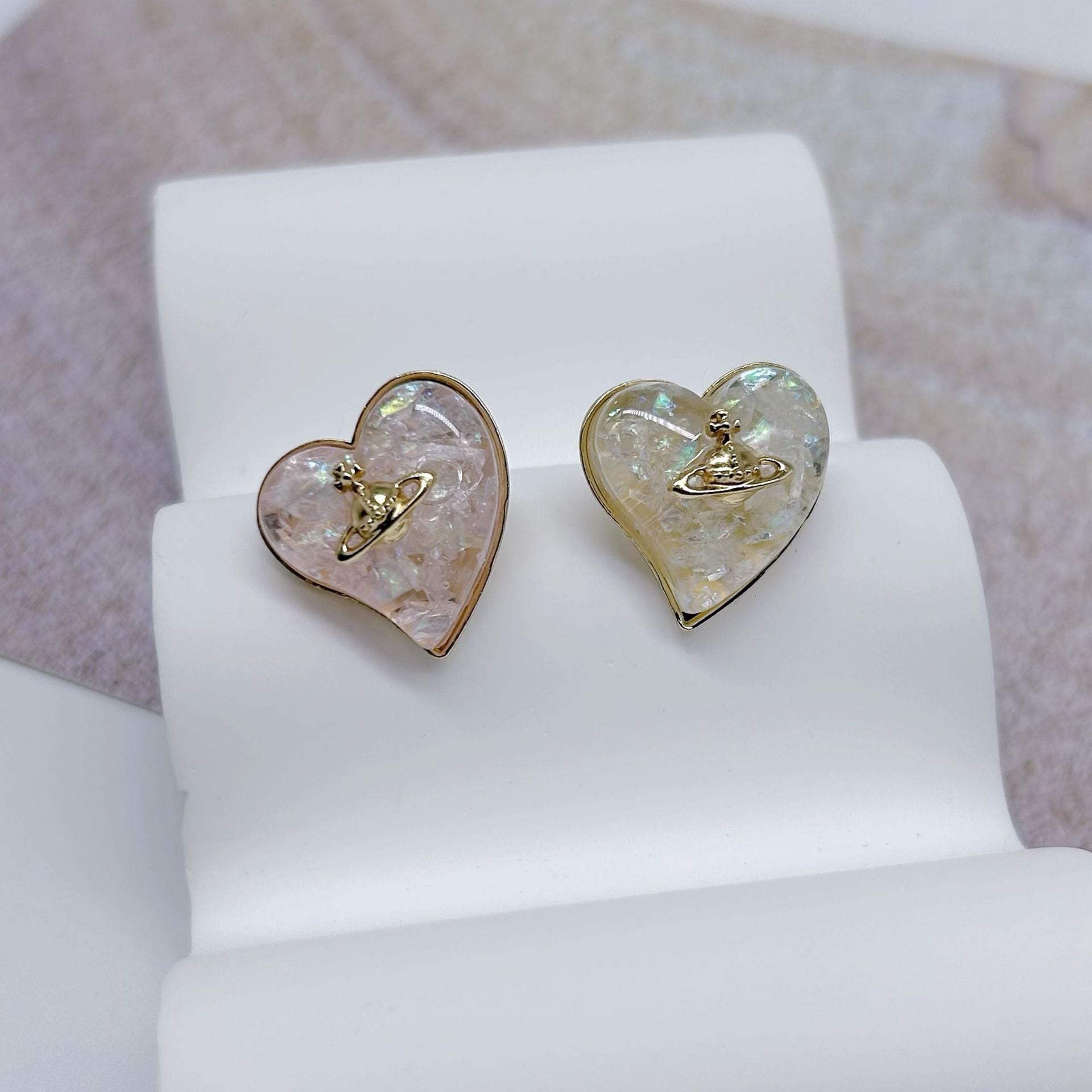 Set of two heart buttons with iridescent resin faces and gold-tone engraved emblem
