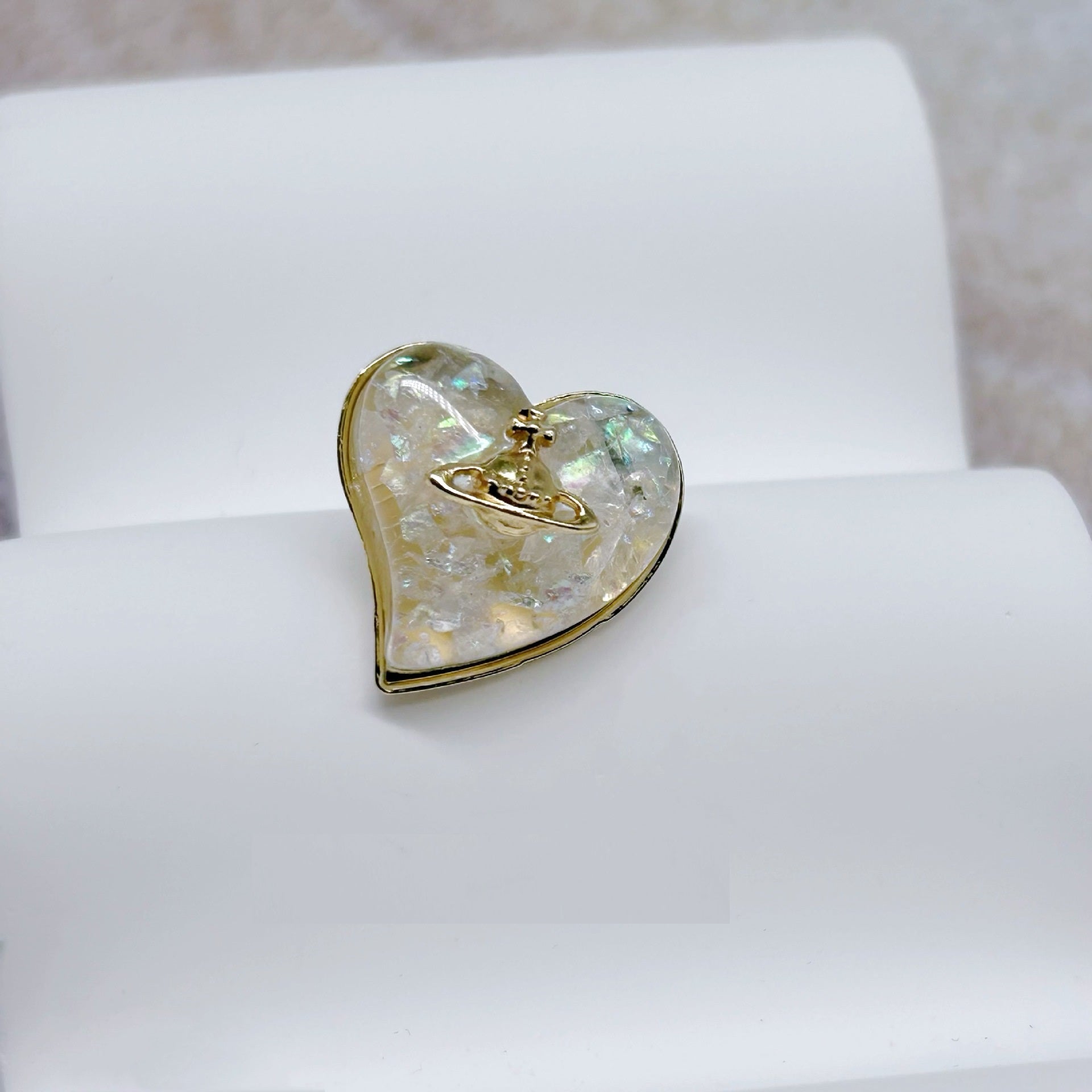 Heart-shaped button front view, iridescent resin with gold-tone metal border and shank