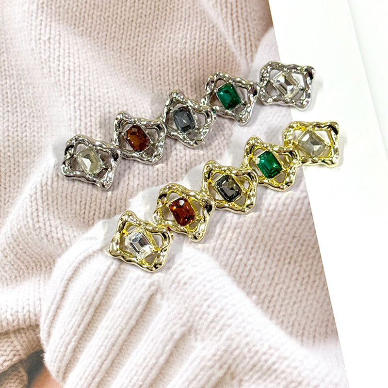 Rectangular rhinestone gem buttons with green, clear, and amber crystals in metal settings