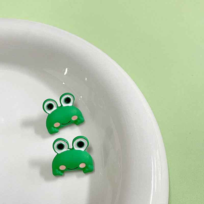Green cartoon frog metal buttons with shanks, kids clothing, front view of two buttons