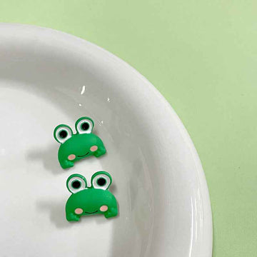 Green cartoon frog metal buttons with shanks, kids clothing, front view of two buttons