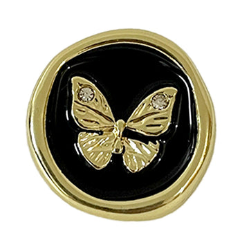 Round metal button with gold rim, black center, diamond butterfly pattern and gem accents