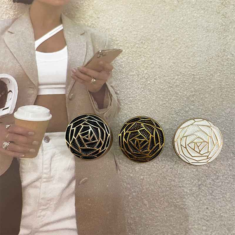 Three woven metal floral buttons: black, bronze, and white with gold-toned rims