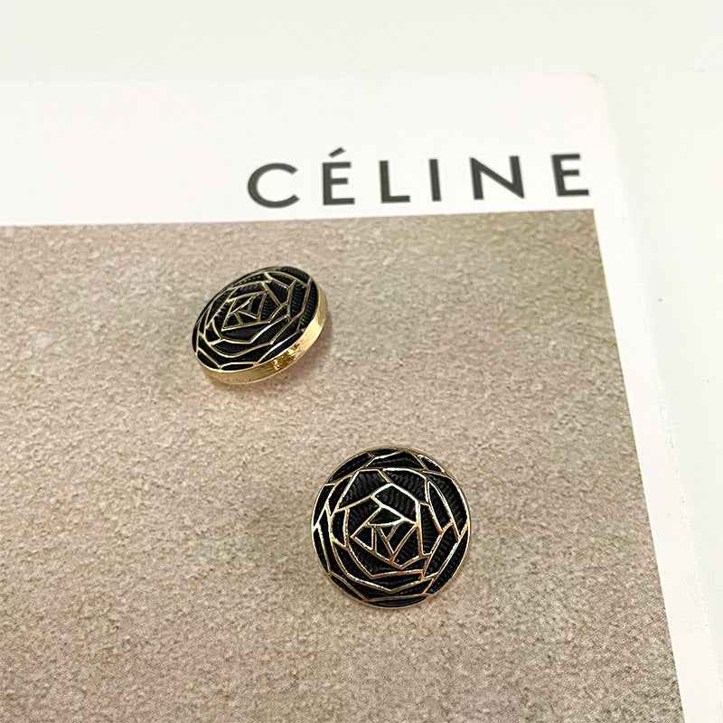 Black woven floral metal button with geometric flower-core pattern and gold trim