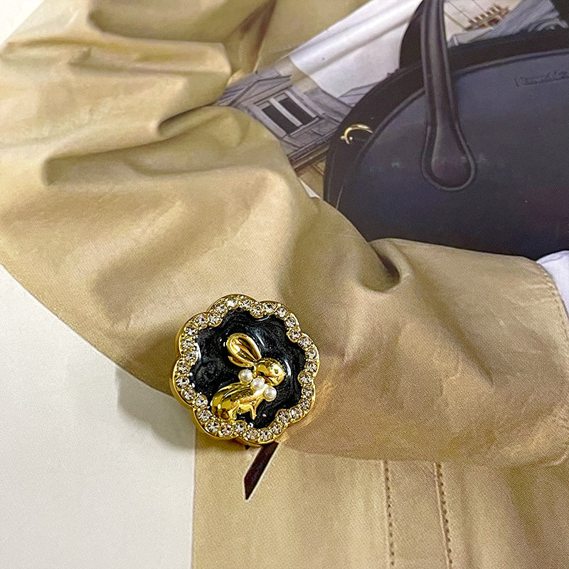 Black bunny suit button with gold-tone rabbit charm, pearls, and rhinestone trim