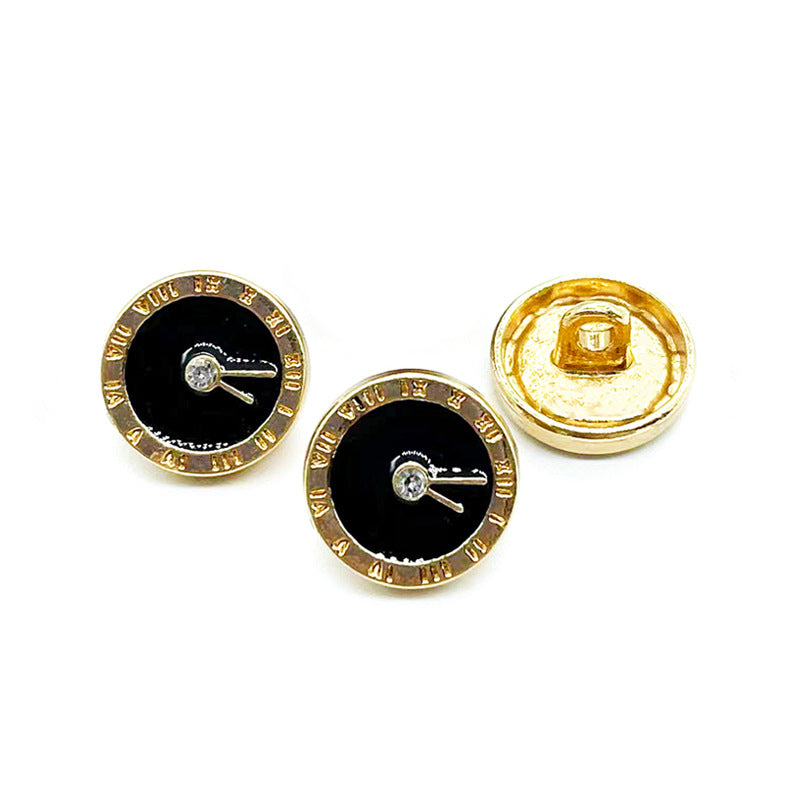 Two front clock-style buttons: black enamel faces with gold-tone rim; one gold-tone back