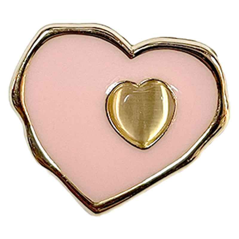 Pink heart sewing button close-up with metallic gold-toned inner heart