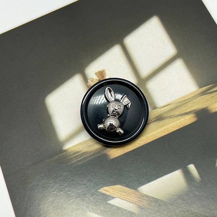 Black resin rabbit round button with silver-tone metal rabbit details, dual-tone design.