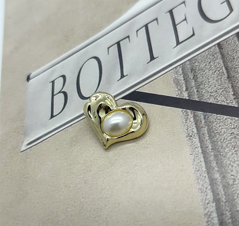 Gold heart-shaped pearl metal button with irregular border and white center pearl