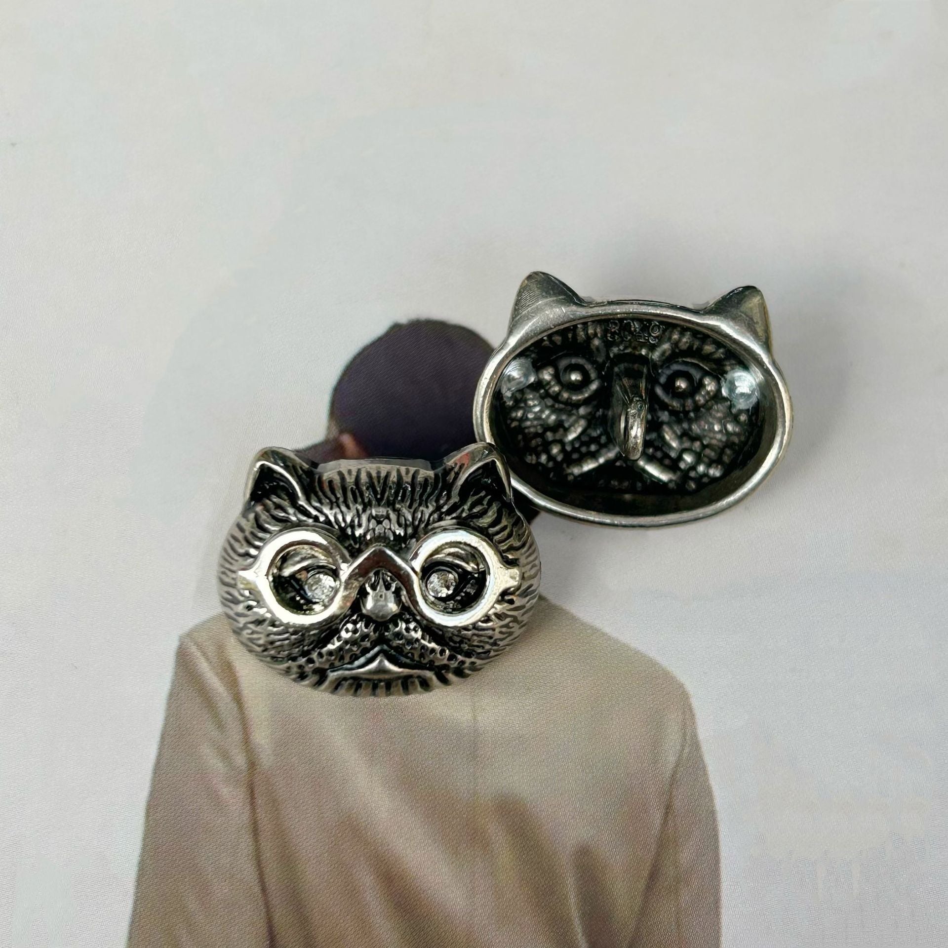 Antique silver cat-head sewing button with dark inlay, raised eyes, whisker texture