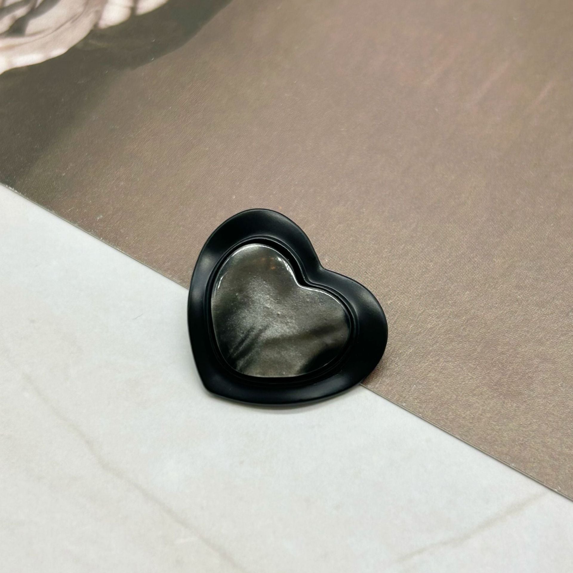 Black heart-shaped resin alloy button with glossy resin face, pearlized trim
