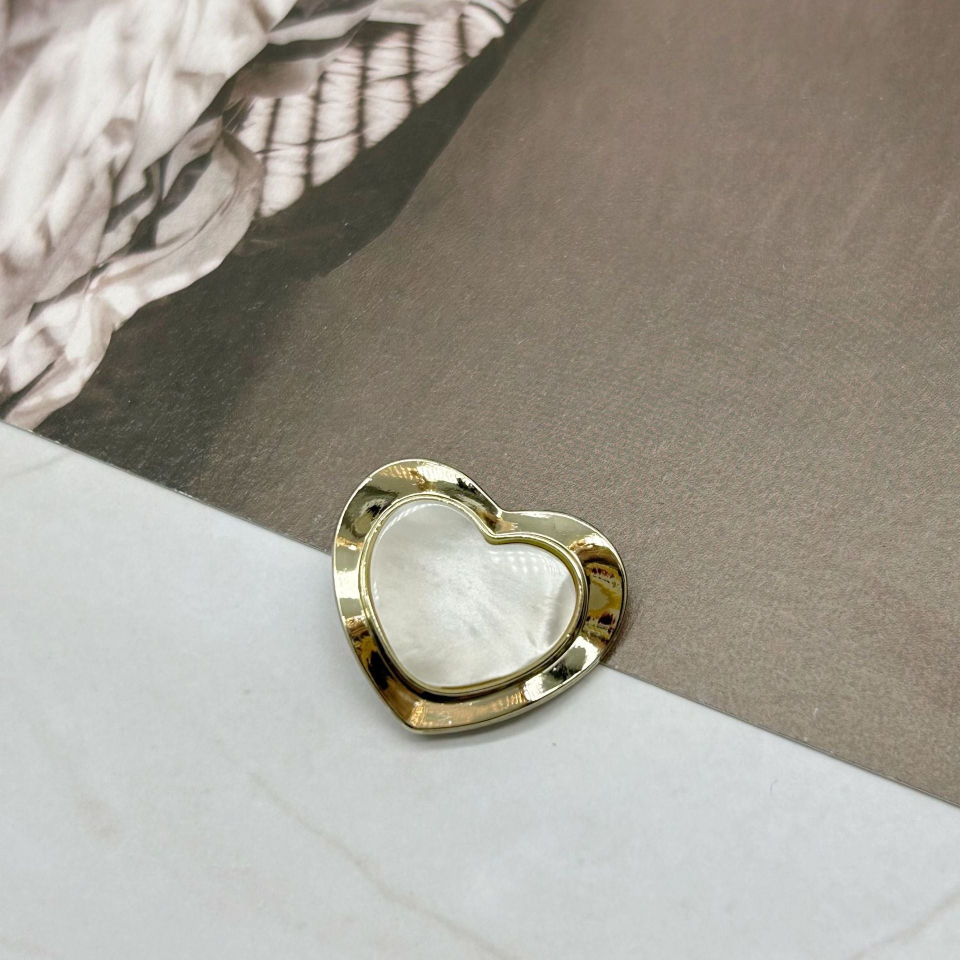 Gold heart-shaped resin alloy button with off-white resin center, pearlized rim