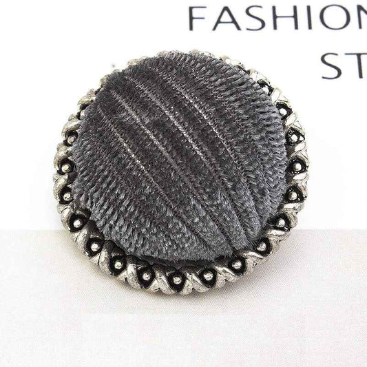 Grey velvet-wrapped metal button with lace-edged scalloped rim and textured stripes