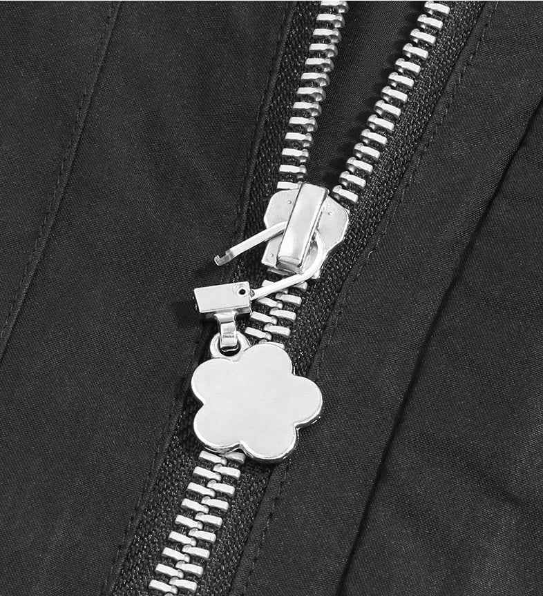Flower-shaped metal zipper pull charm attached to black zipper slider, silver tone