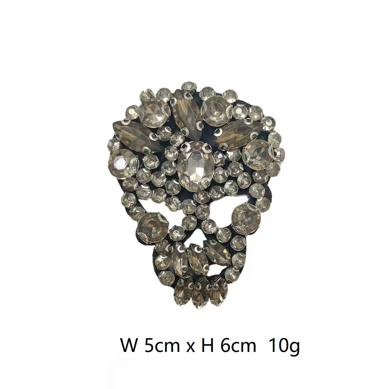 Rhinestone skull patch in dark smoky tones with scattered clear faceted stones