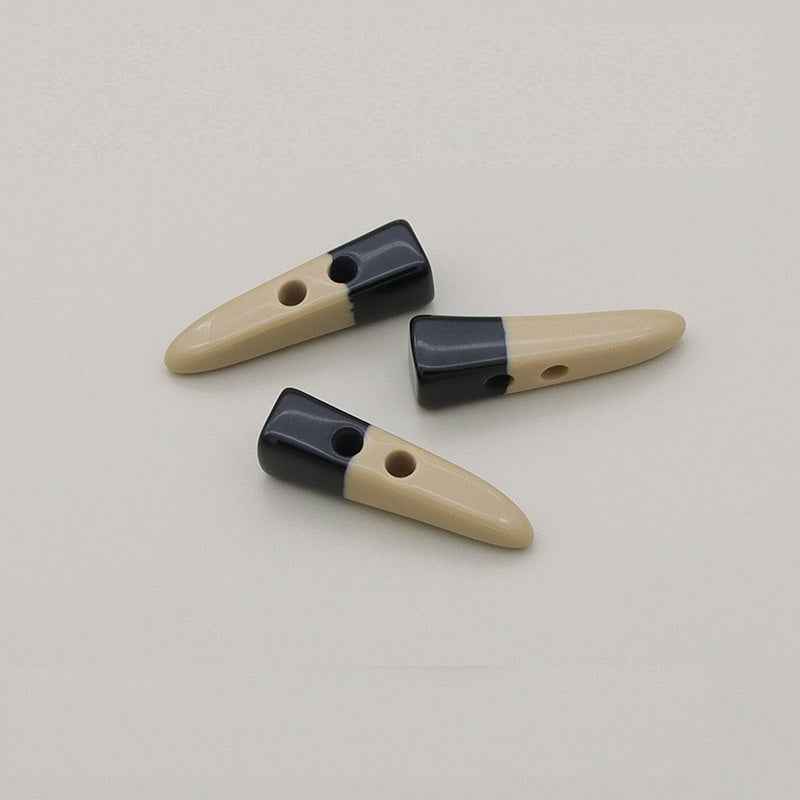Horn-shaped resin toggle buttons, beige with dark ends, three pieces shown