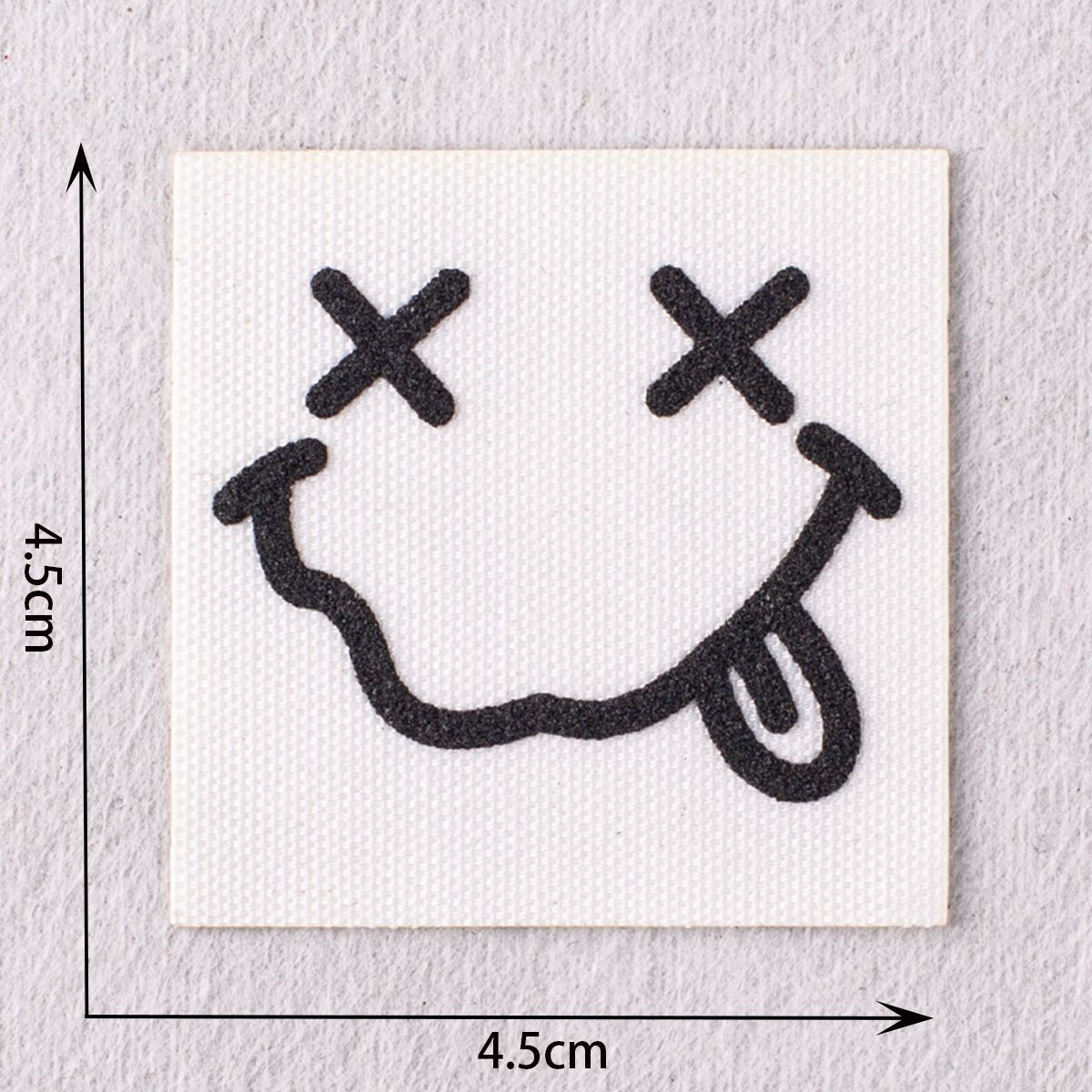 Black facepatch with crossed eyes and smiley mouth, text-free design