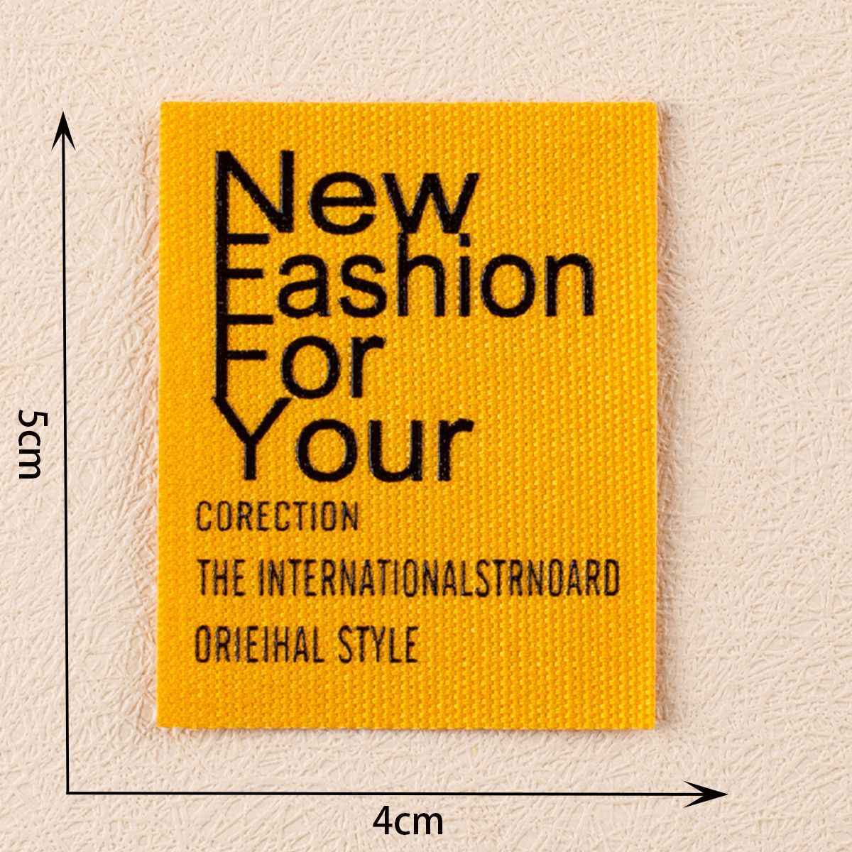 Yellow fabric label, New Fashion For Your, ~4×5 cm