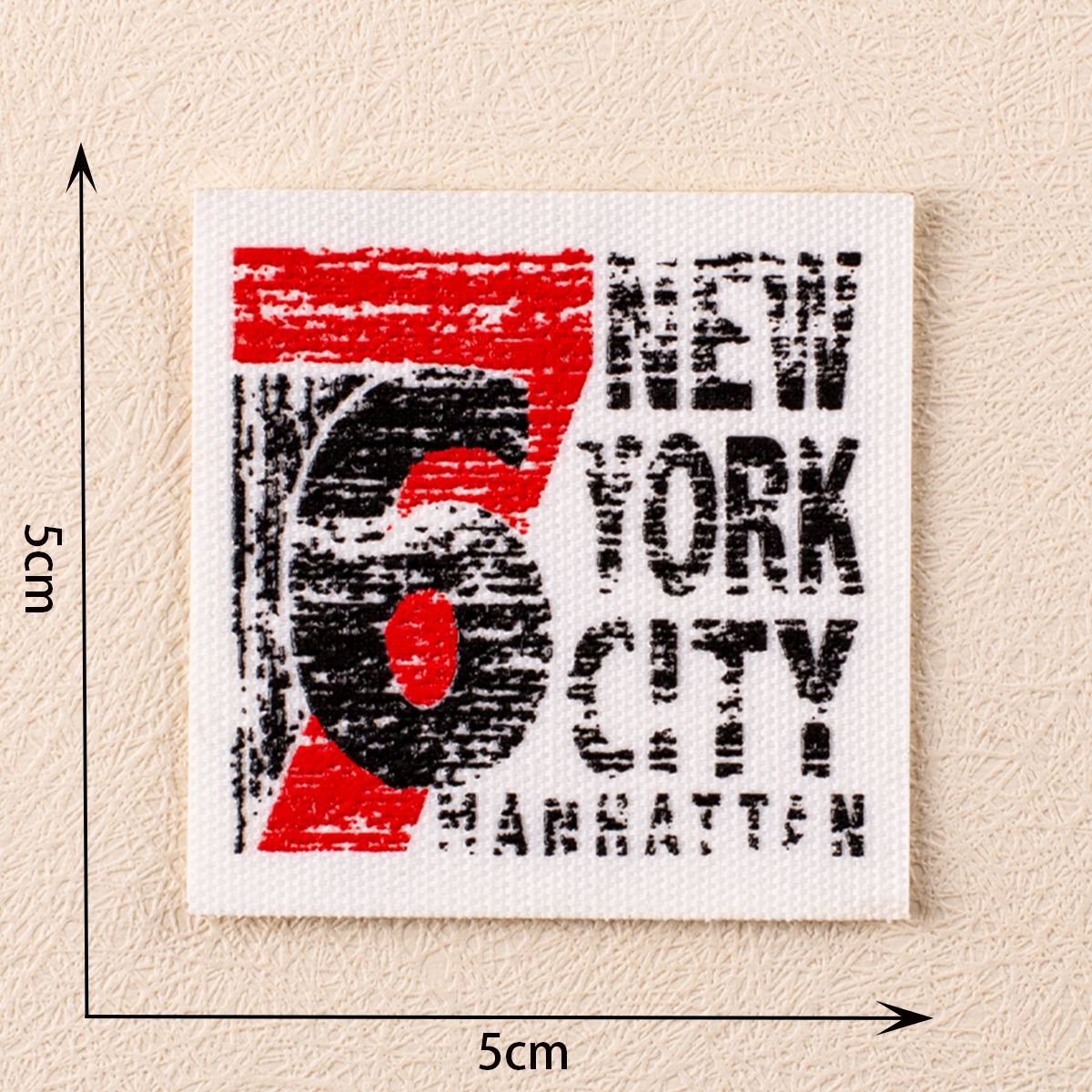 White fabric patch with red and black numbers 5 and 'New York City' text