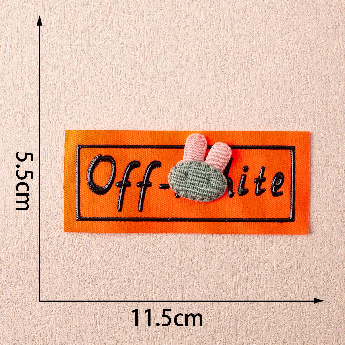 Off-White fabric label on orange with bunny appliqué and pink ears