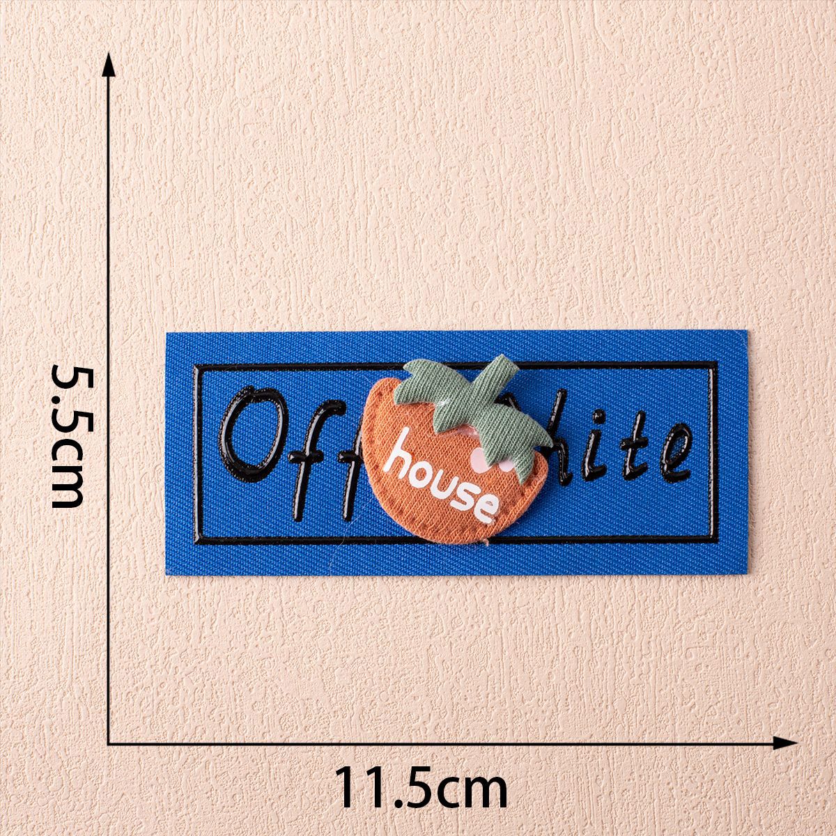 Off-White fabric label on blue with strawberry appliqué and stitched lettering