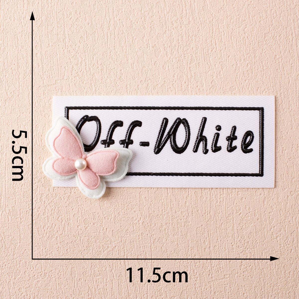 Off-White fabric label on white with pink bow and small pearl center