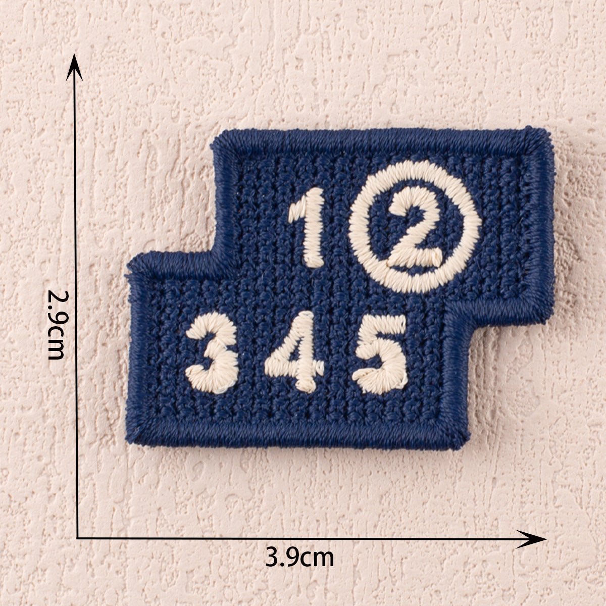 Blue fabric patch with white numbers 1 2 3 and a circled 2 on top, 3.9cm x 2.9cm.