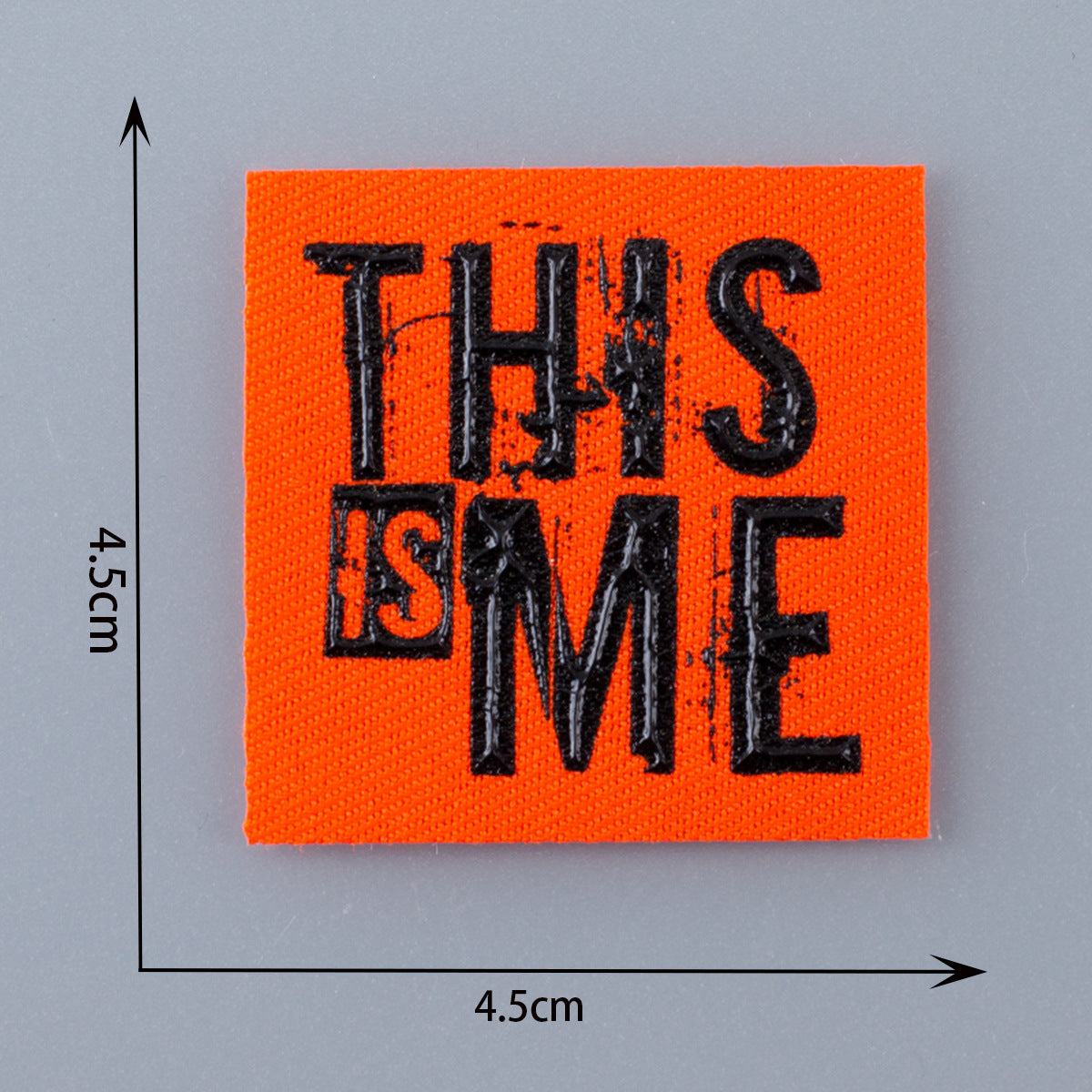 Oranges 3D Patch-Abzeichen mit „THIS IS ME“ in Schwarz.