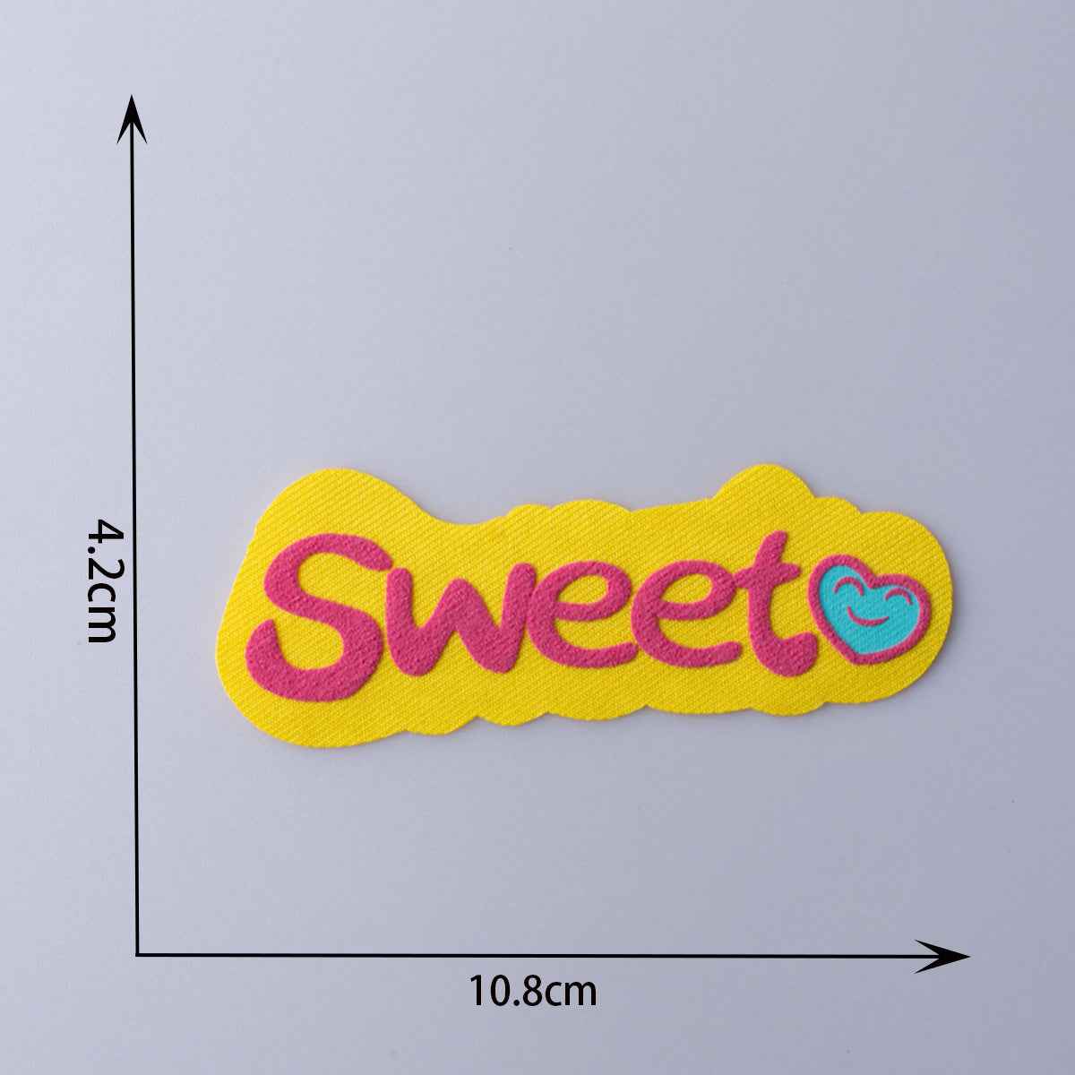 “Sweet” fabric patch, yellow with pink letters and teal swirl face detail