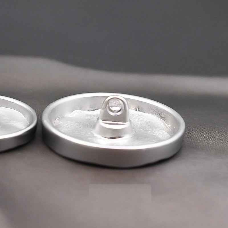 Silver metal shank button underside with central post for sewing